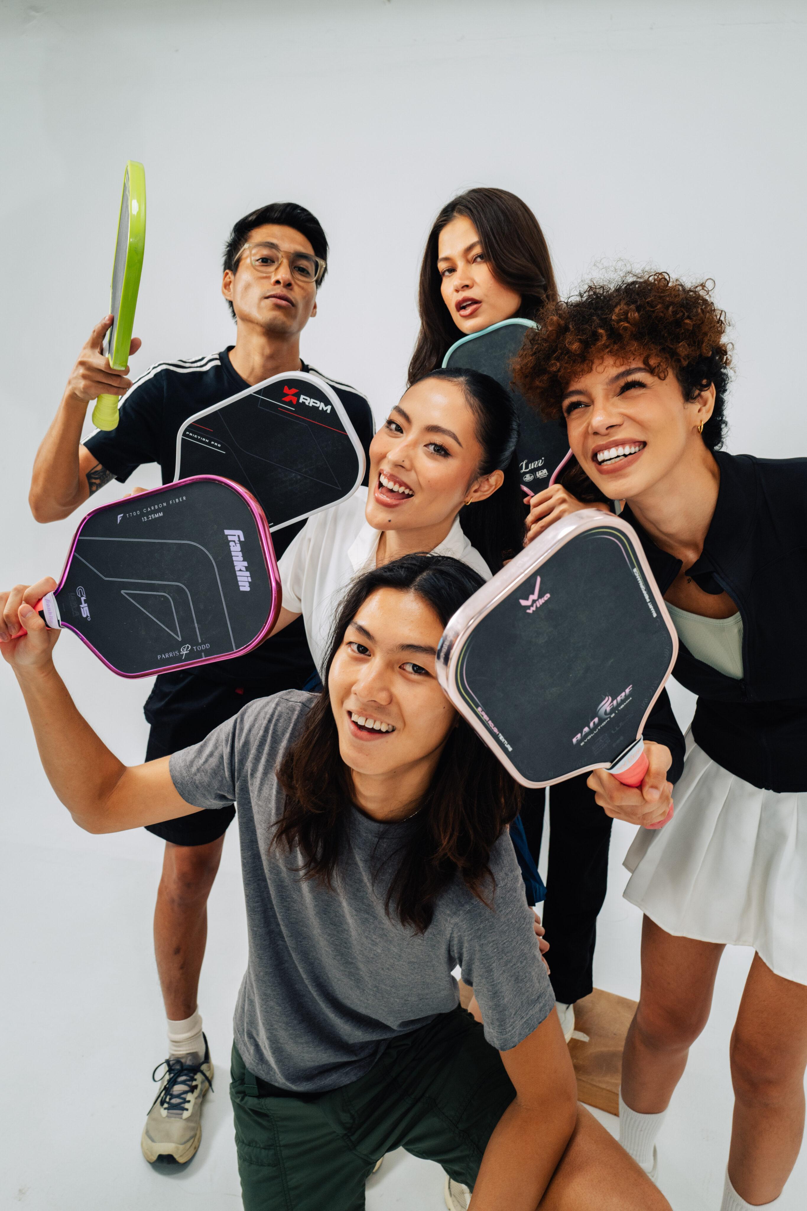 Pickleball players holding up their paddles